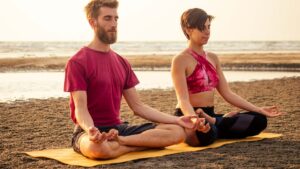 Joga i medytacja to metoda uzdrowanie czakr- para na macie medytuje